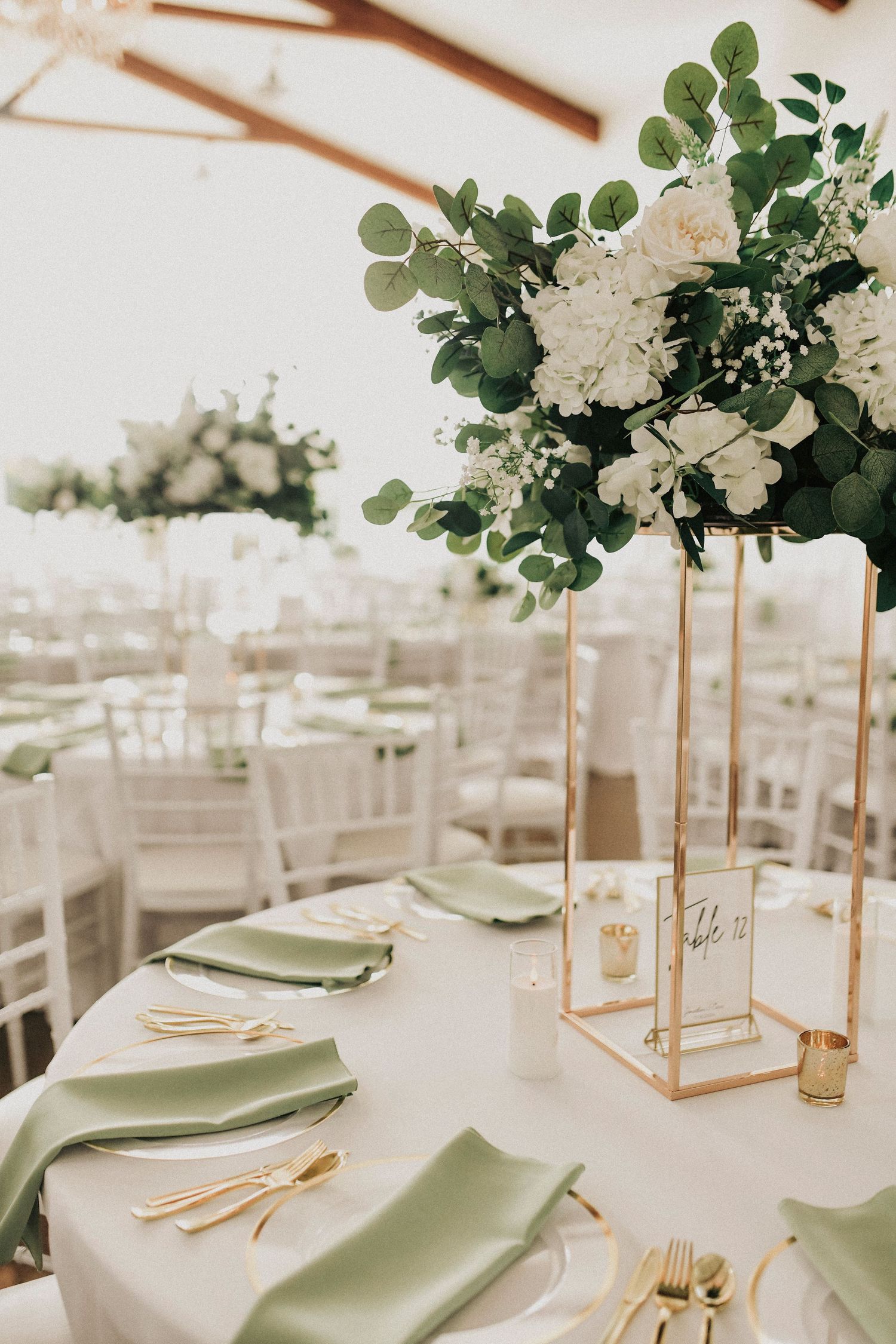 Reception tables styled with ivory linens and gold flatware at dallas wedding venue