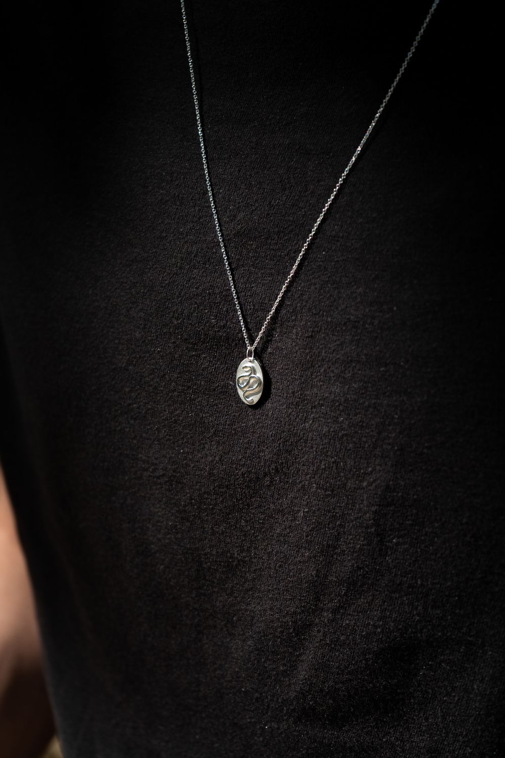 Delicate silver heart pendant necklace on dark background shown in sequence from different angles and distances.