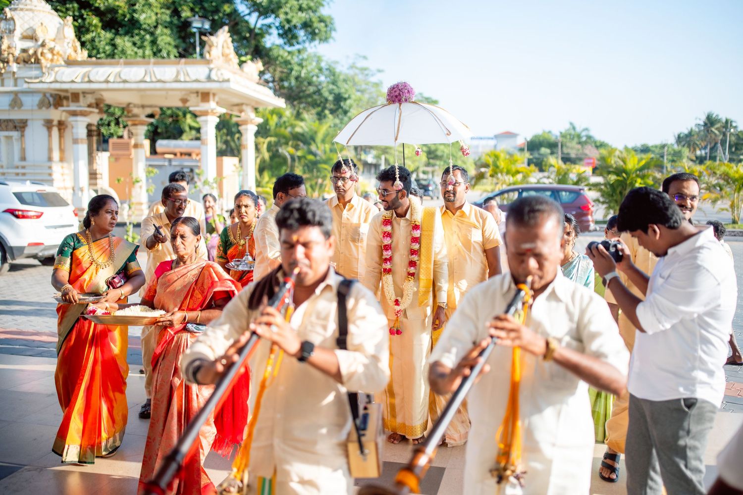 Groom Kathir performing the traditional Kashi Yatra ritual with a decorated umbrella and walking stick at Eeebees Mahal, Erode.