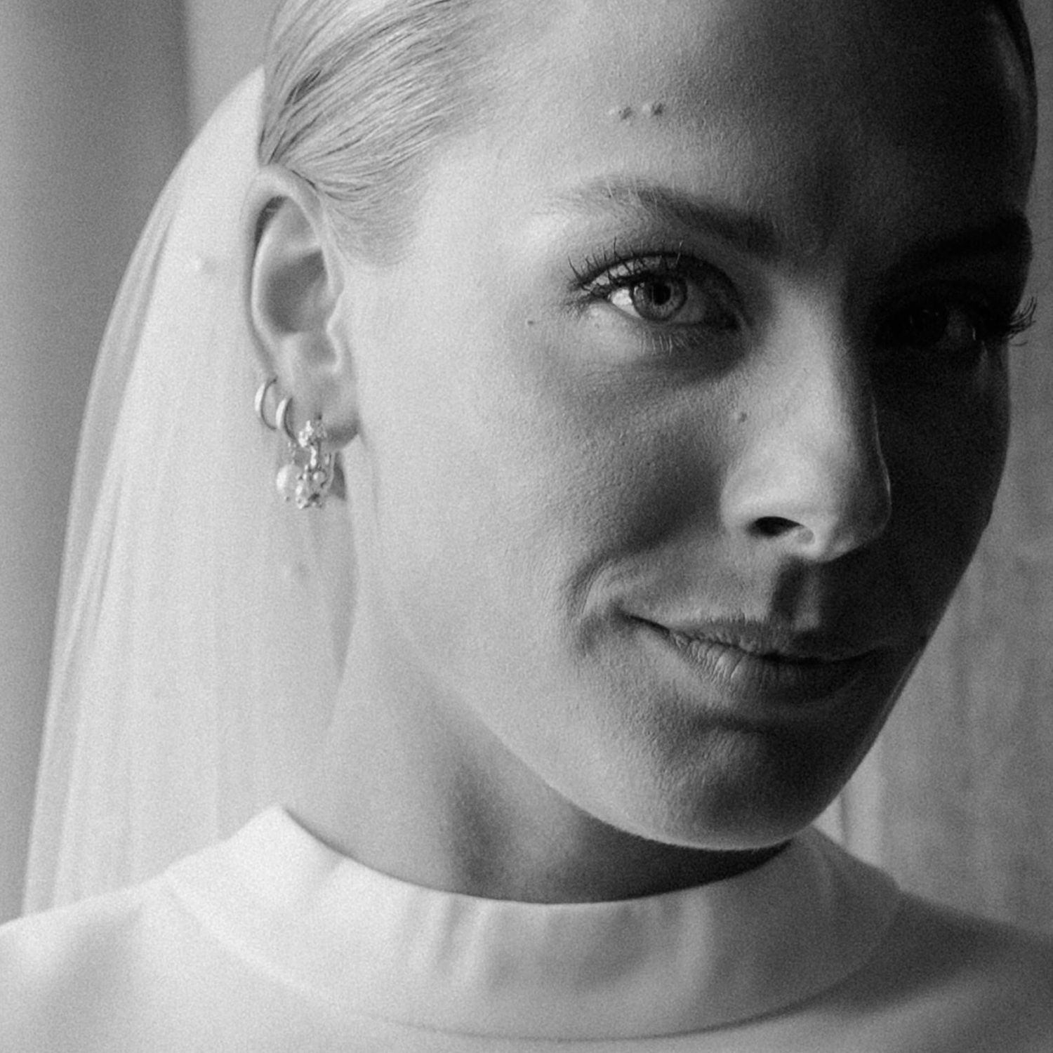 Black and white portrait series showing different angles and expressions in soft lighting against a light background.