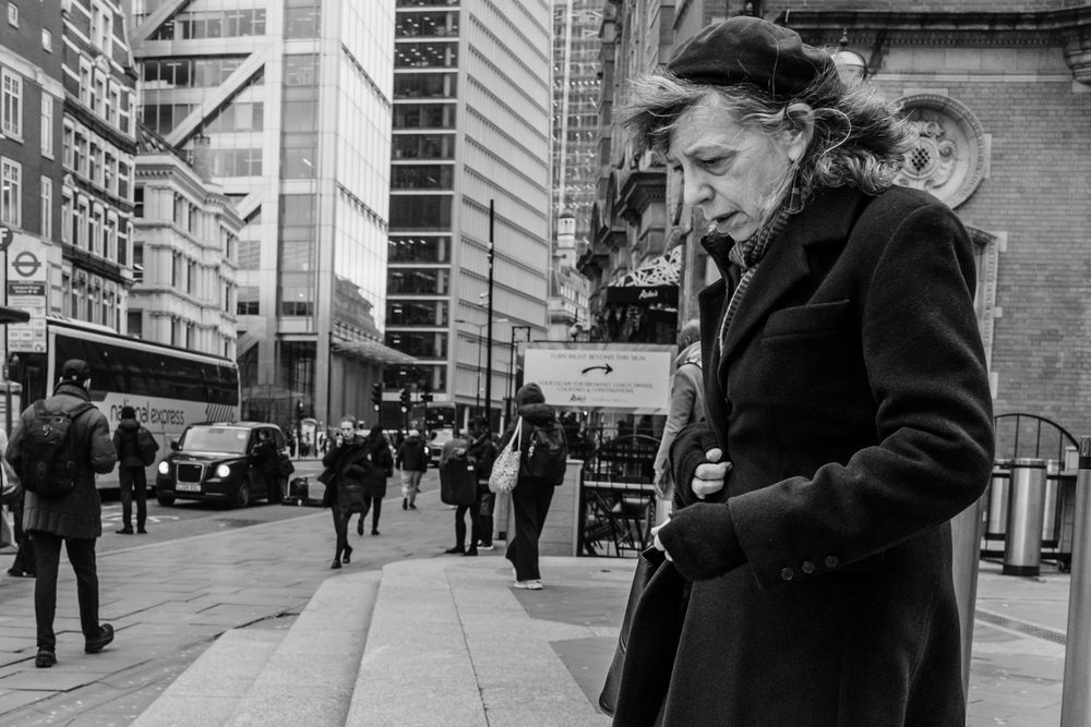 A black and white photo collage shows people walking on city streets and interacting in urban environments.