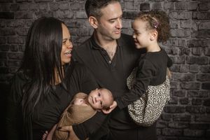 Newborn baby with parents and sister