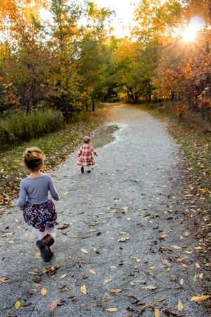 Fall Family session sister running through leafy path
