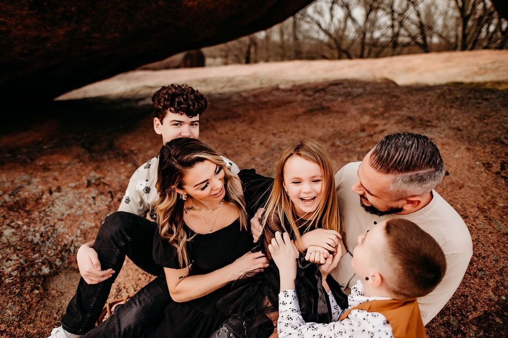Family group shares joyful laughter while gathered close together outdoors.