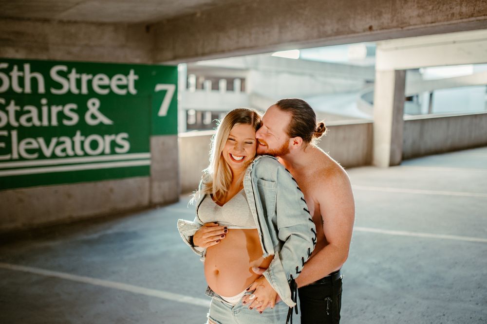 Intimate moment shared in urban parking garage with '5th Street' sign visible.