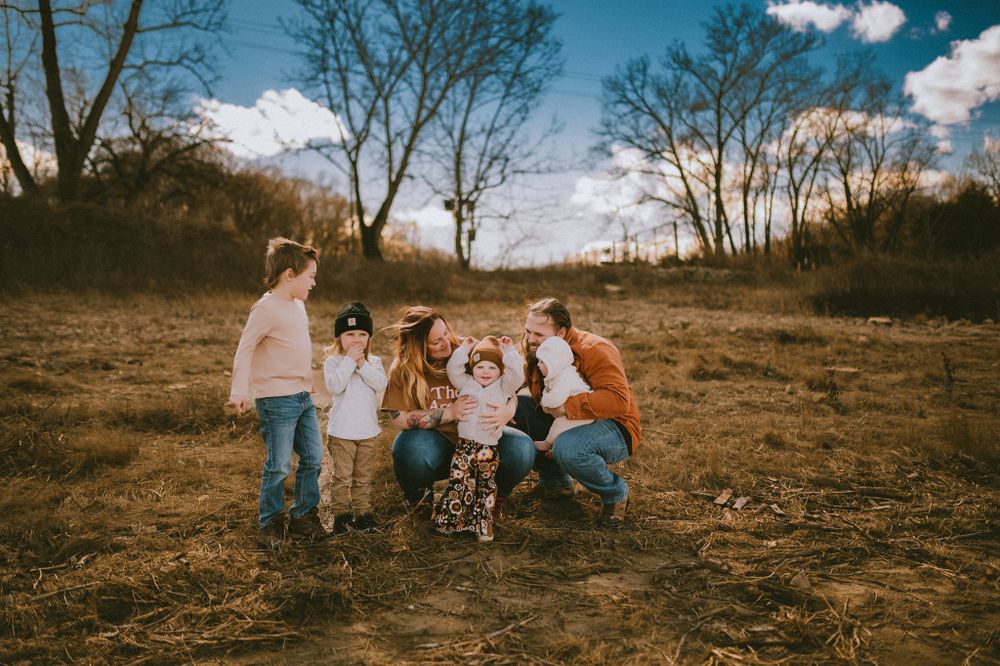 Candid family moment captured in an open field during late autumn.