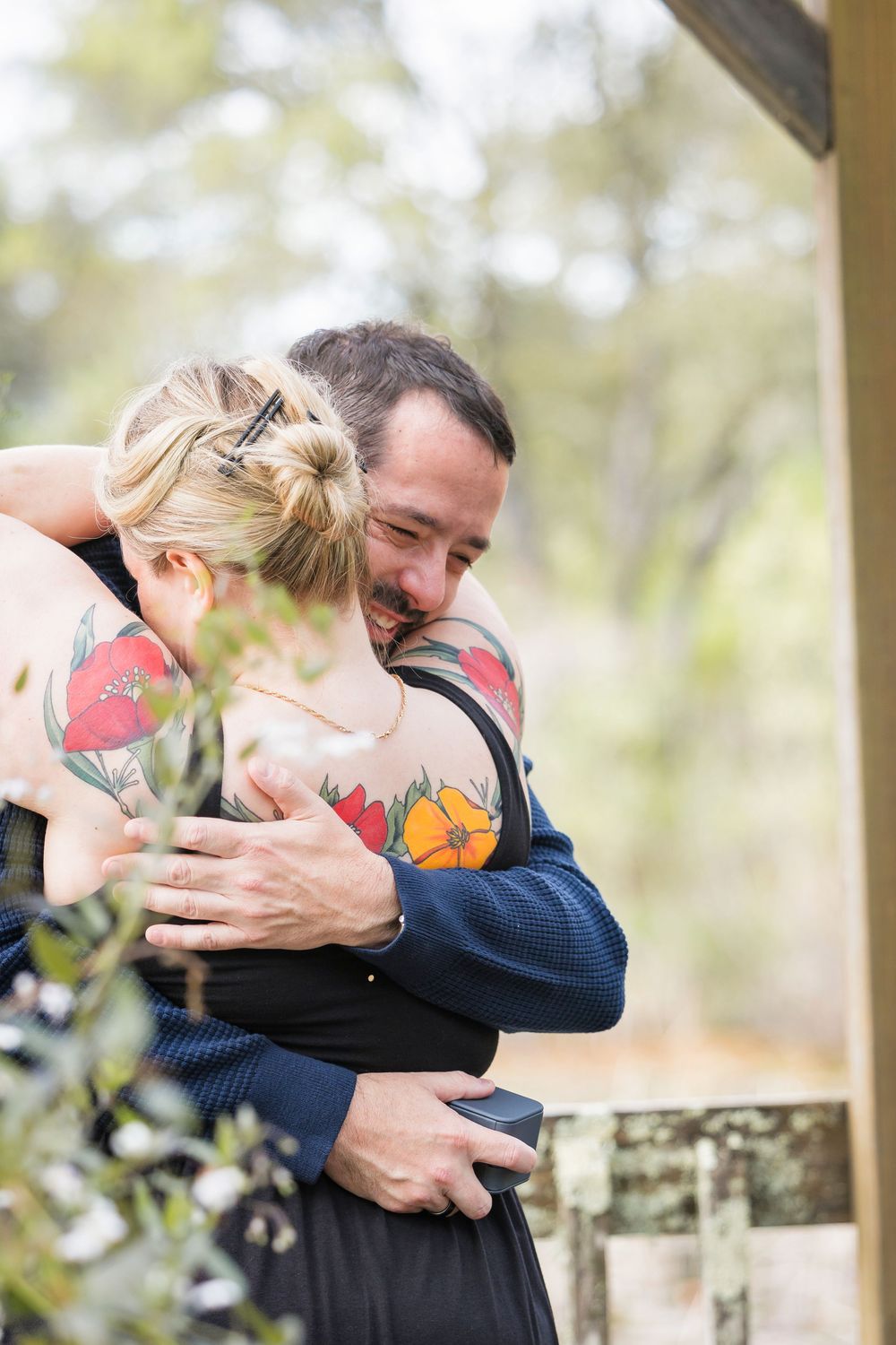 A couple shares an intimate embrace during what appears to be an outdoor photo session.