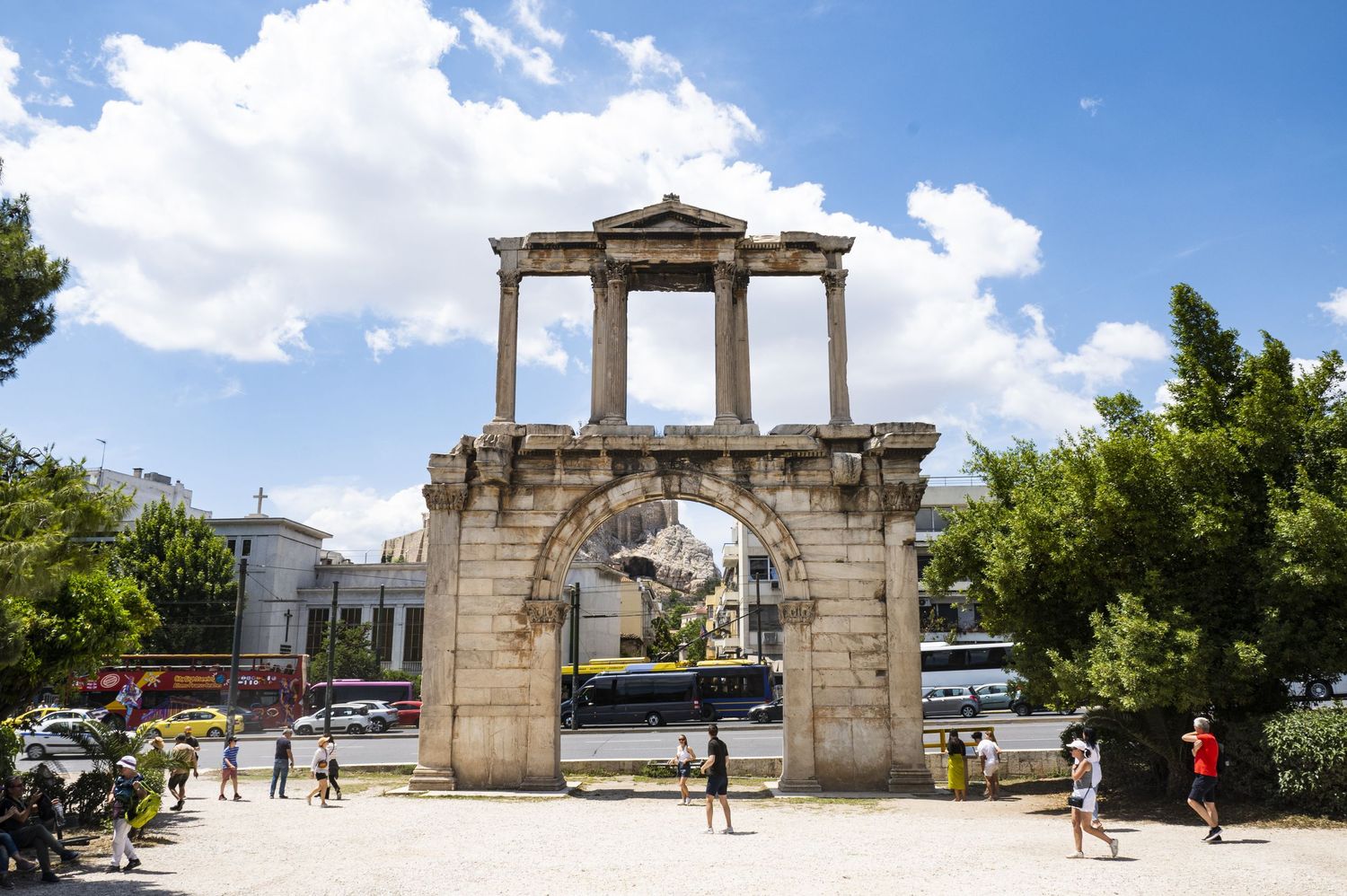 Hadrian's Arch, an ancient Roman monument with marble columns, stands against a blue sky in Athens, Greece.