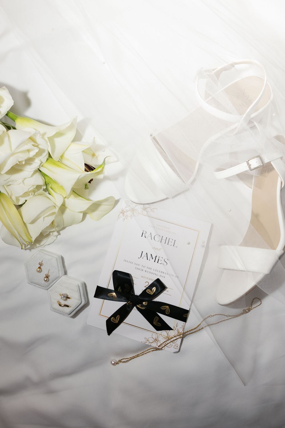 Elegant wedding place cards with black bows and floral accents arranged on a light gray surface.
