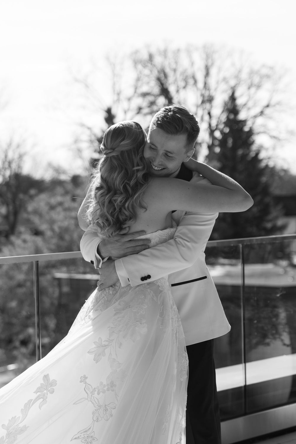Emotional first look sequence showing couple embracing on an outdoor balcony.
