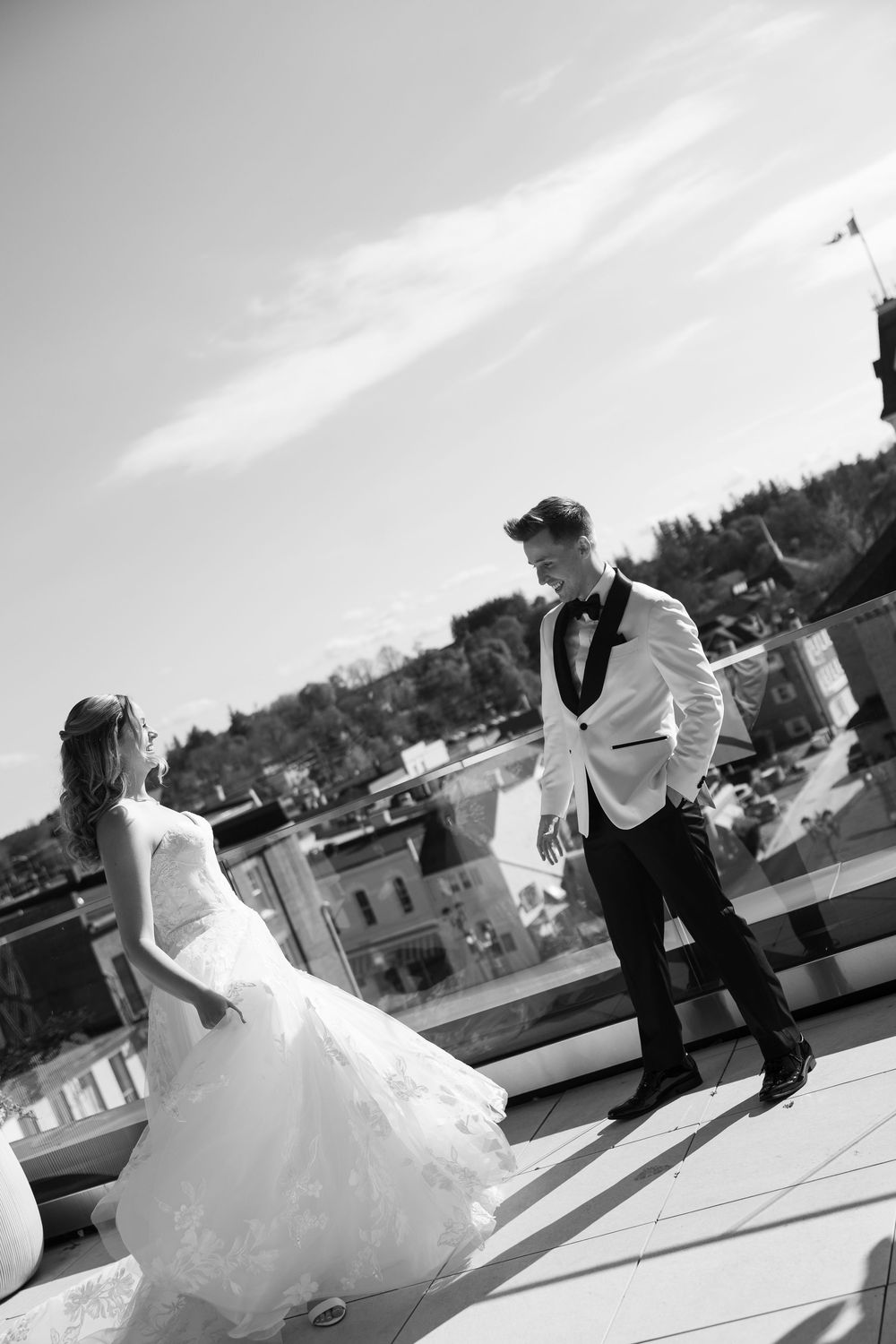 Artistic black and white wedding photos captured from creative angles on a rooftop setting.