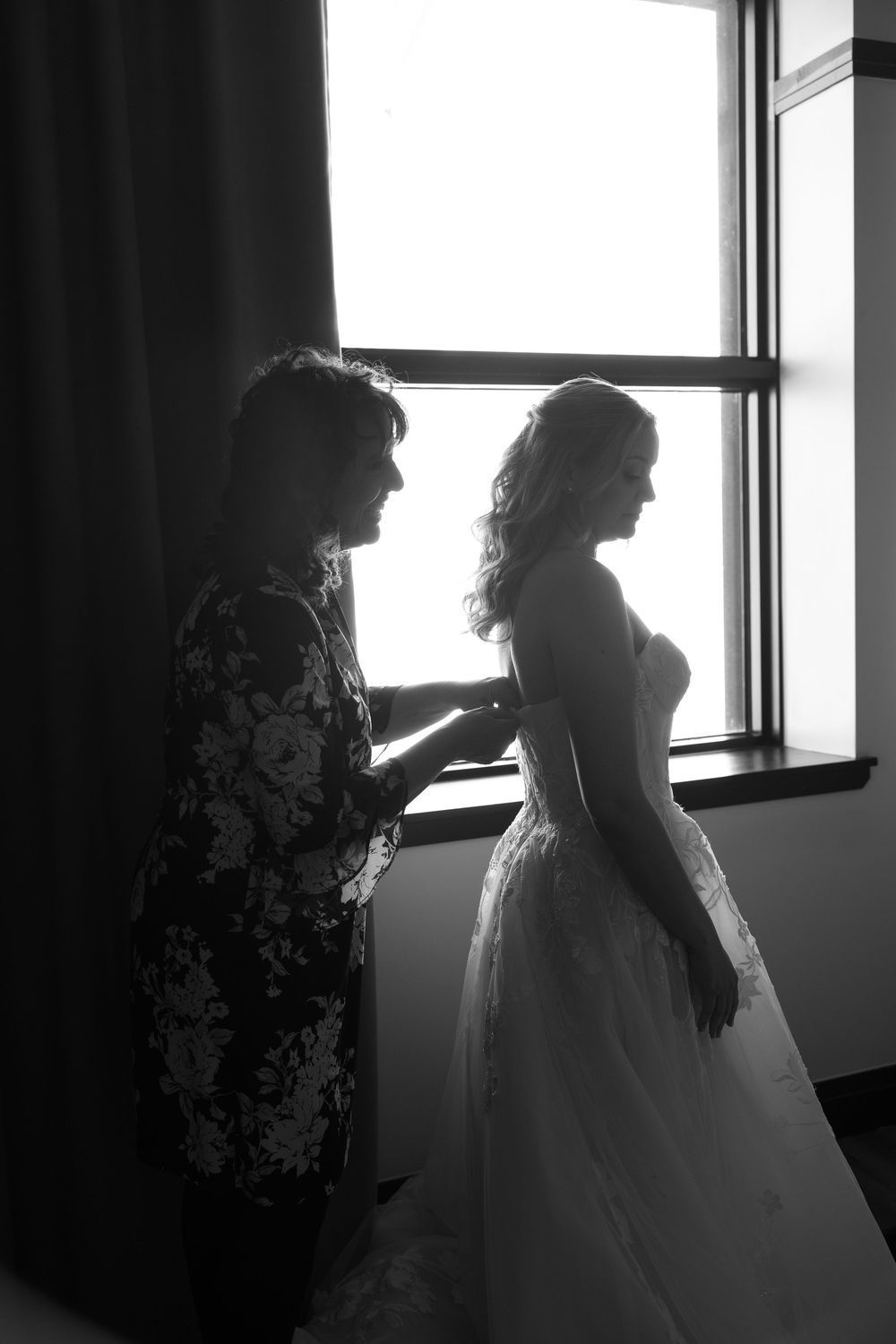 Silhouetted figures stand near windows in dramatic black and white composition showing multiple angles.