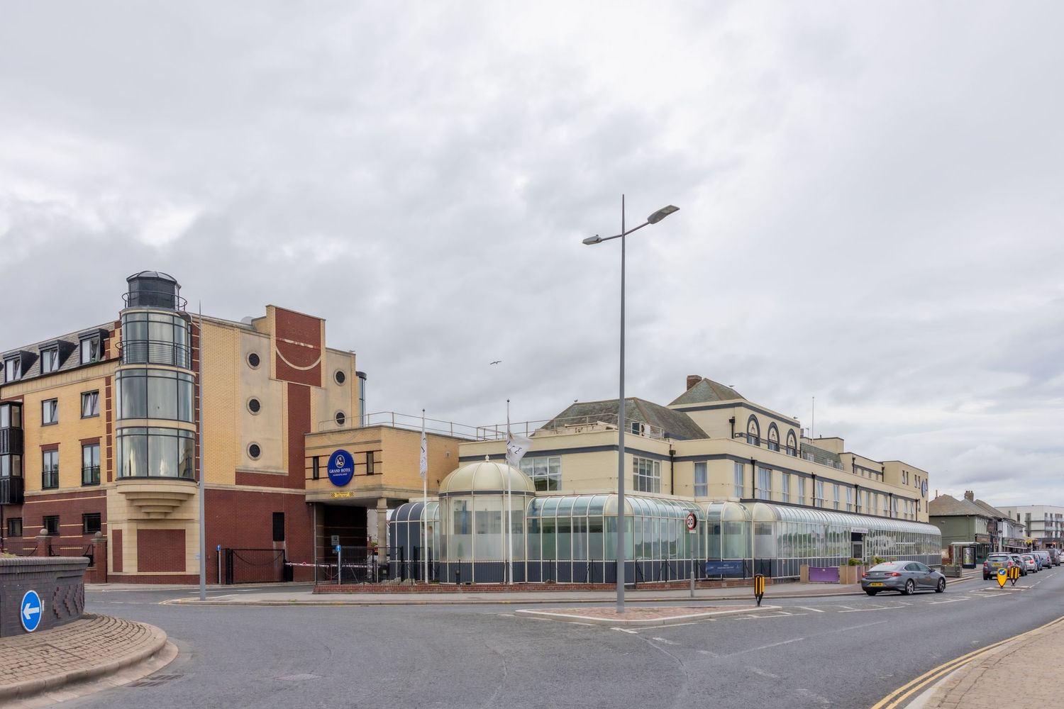 A panoramic view of a coastal town with modern buildings and street lamps along a curved waterfront promenade. Grand Hotel Sunderland