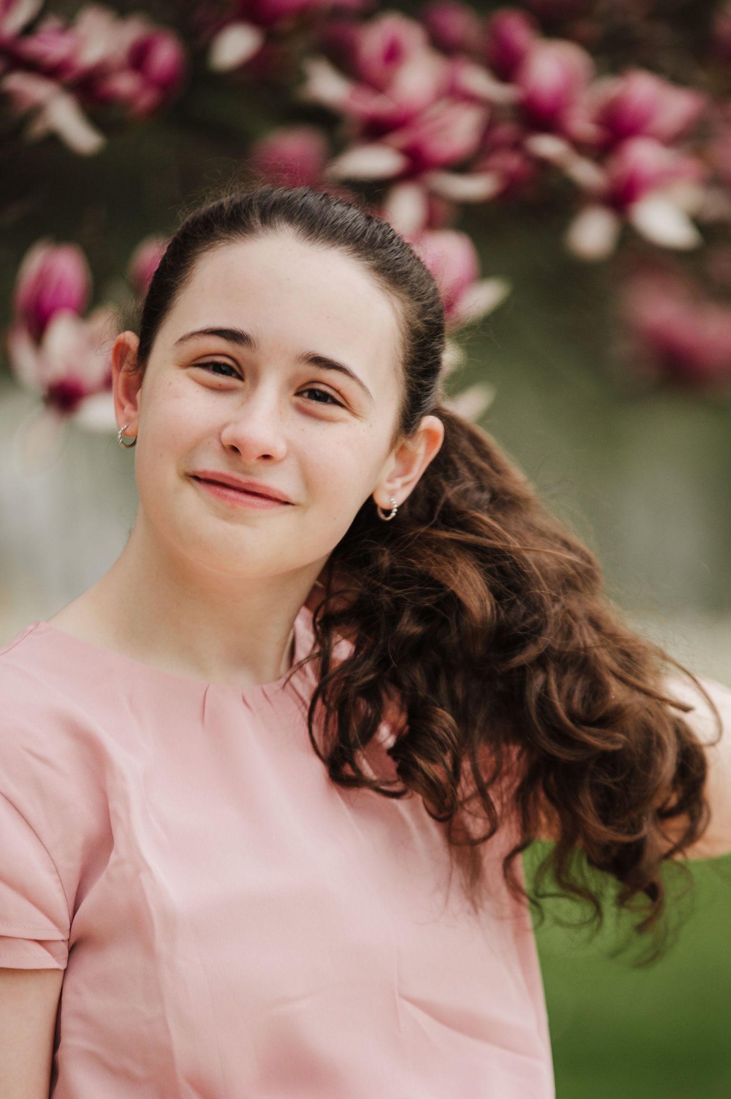 A series of portraits showing joyful expressions against a backdrop of pink spring blossoms.