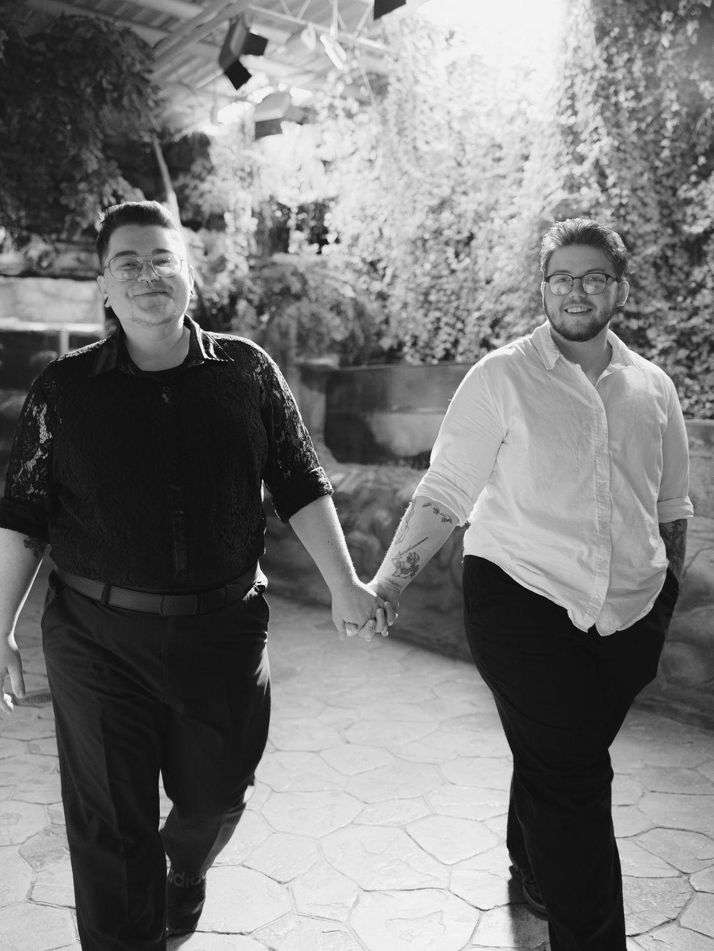 A series of black and white photos showing people posing and laughing together outdoors on a stone patio.