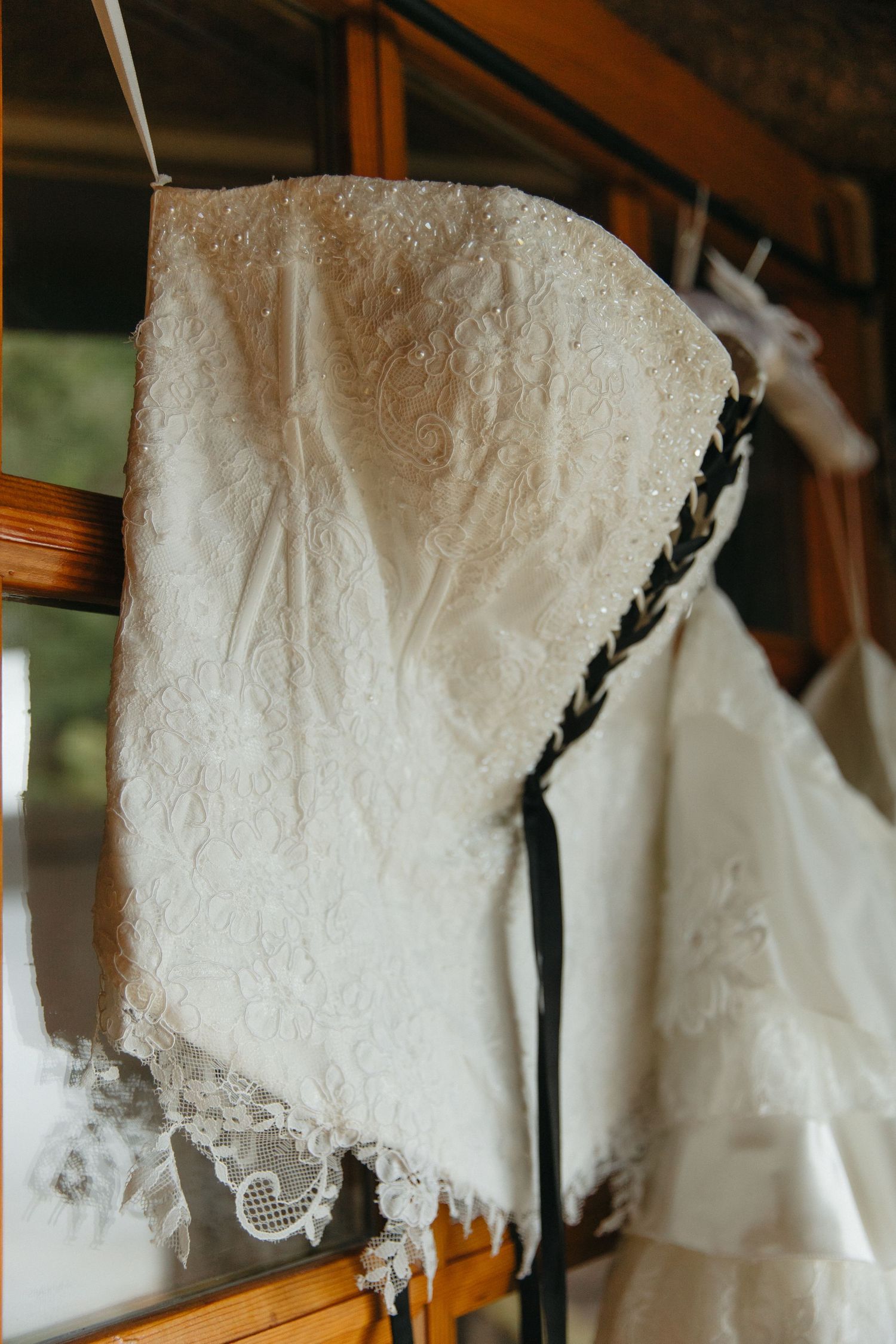 A collection of white lace wedding dresses hanging on display, showing intricate details and delicate embellishments.
