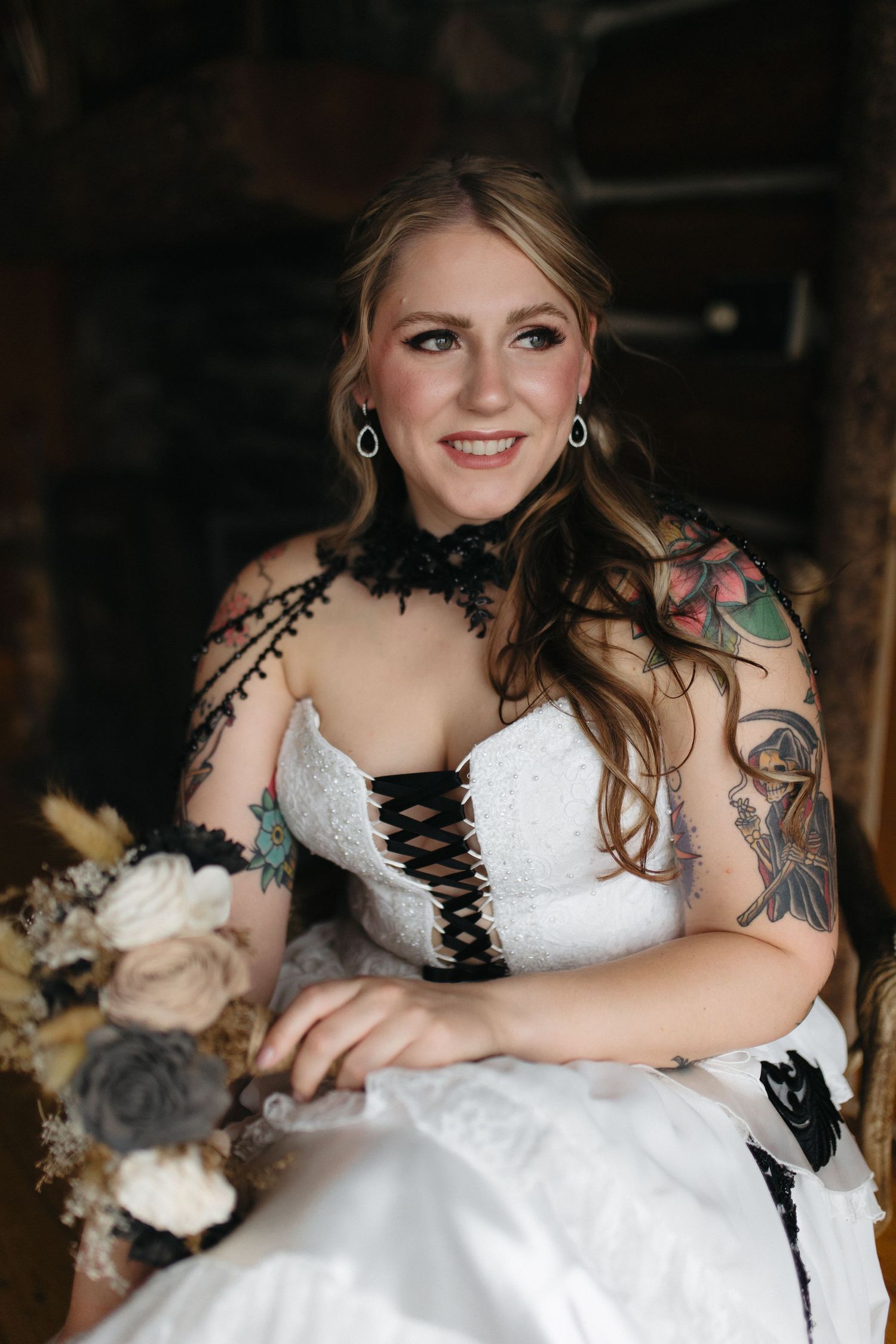 A white wedding dress with black corset details and lace accents.