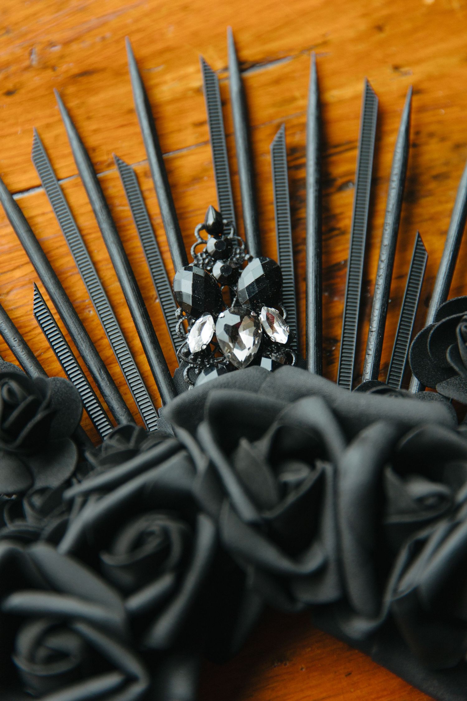 Gothic wedding decor featuring black satin roses and metallic spiked crown arrangement.