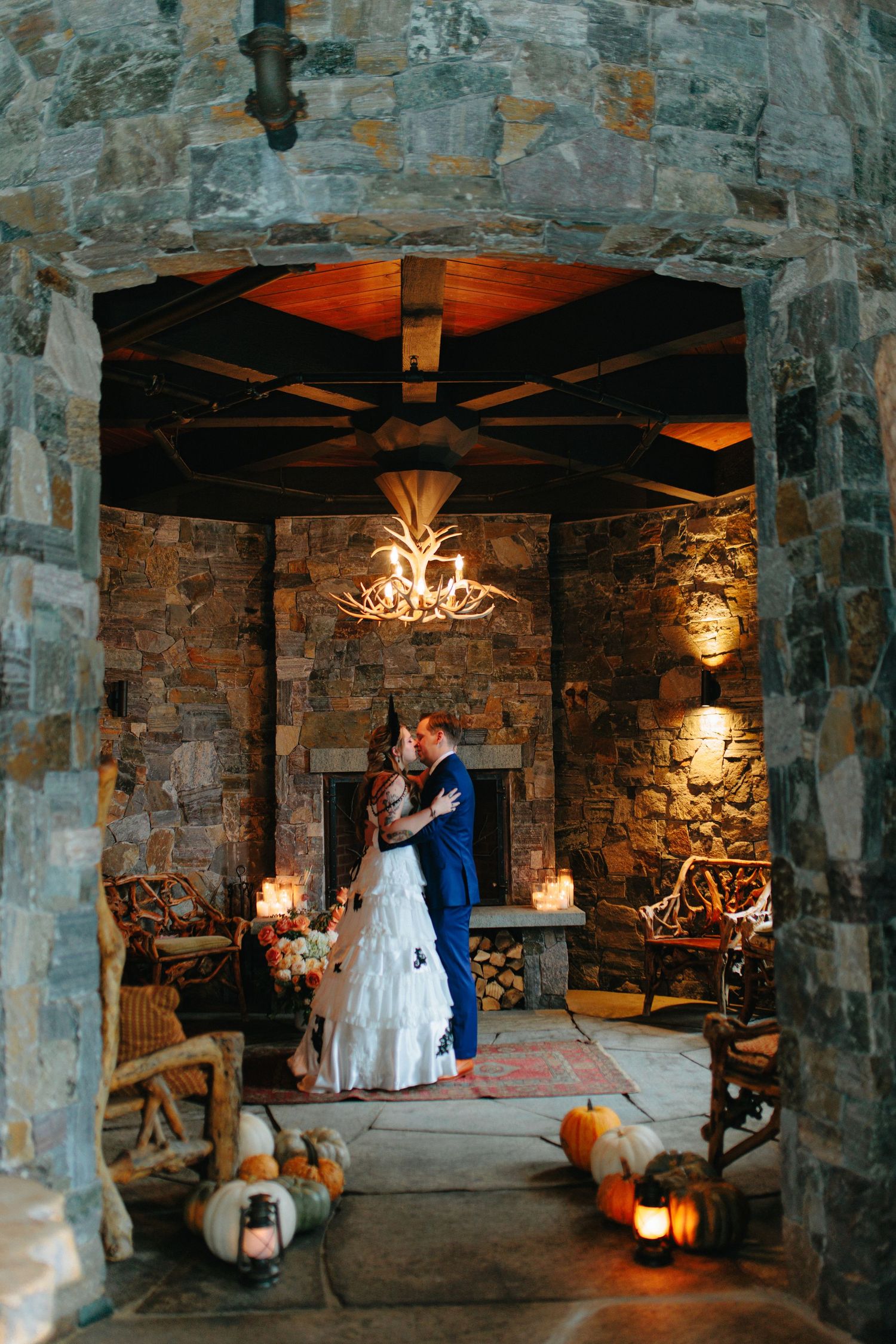 Stone cellar wedding venue decorated with romantic lighting and rustic chandeliers.