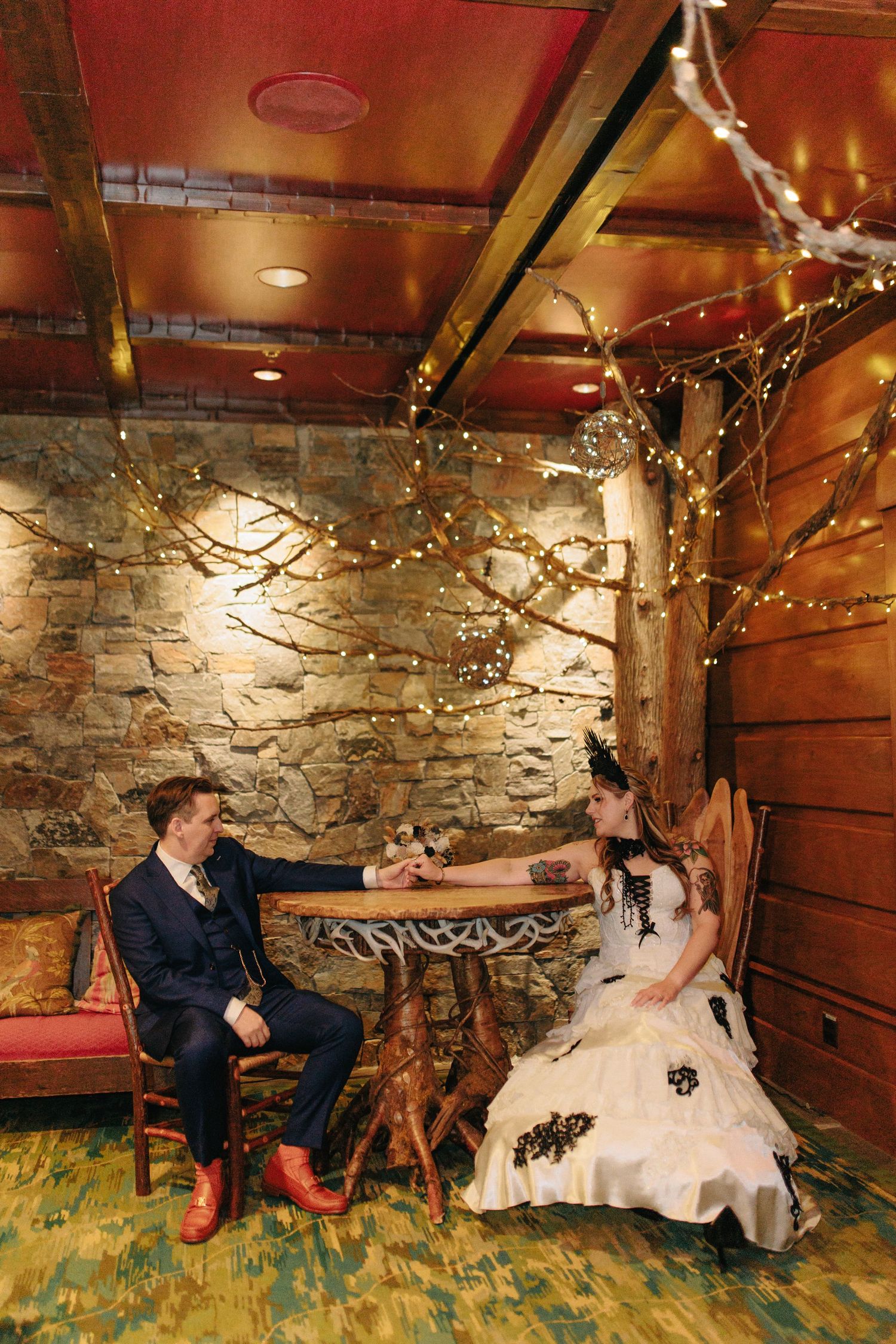 Rustic wedding photo session with stone walls and twinkle lights in romantic indoor setting.