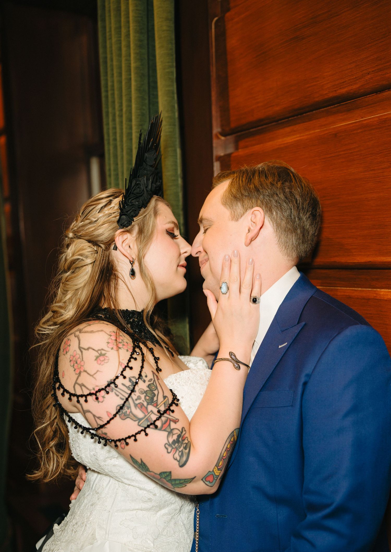 Romantic wedding moment captured in warm lighting against wooden wall backdrop.