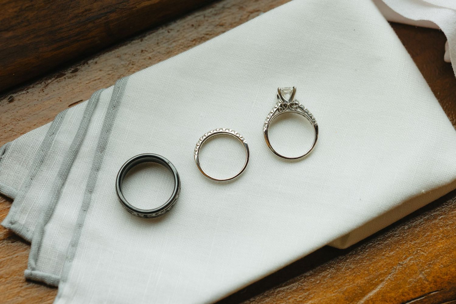 Wedding rings displayed on a white marble surface with elegant styling.