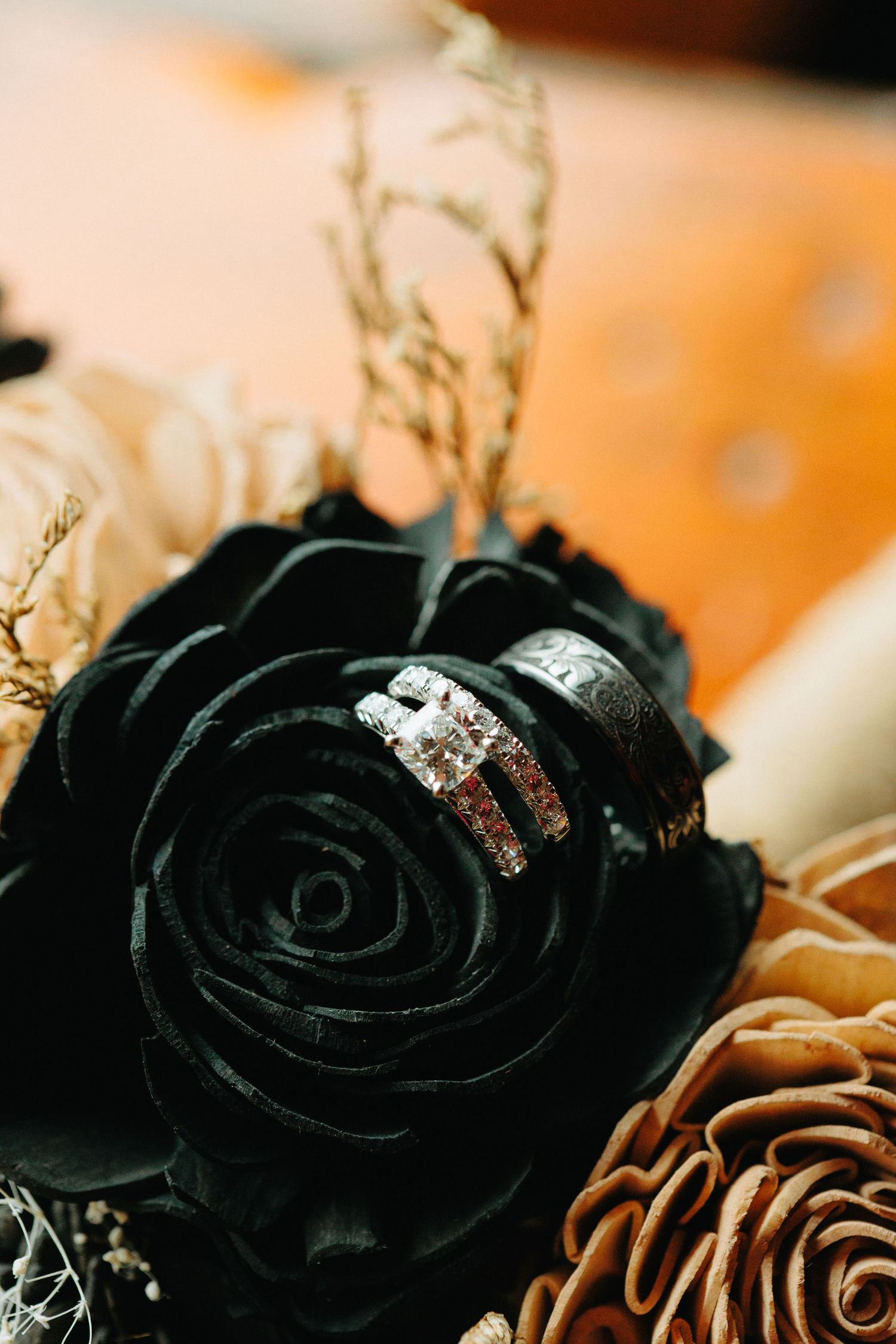 Close-up of black and gold roses with glitter accents in elegant floral arrangement.
