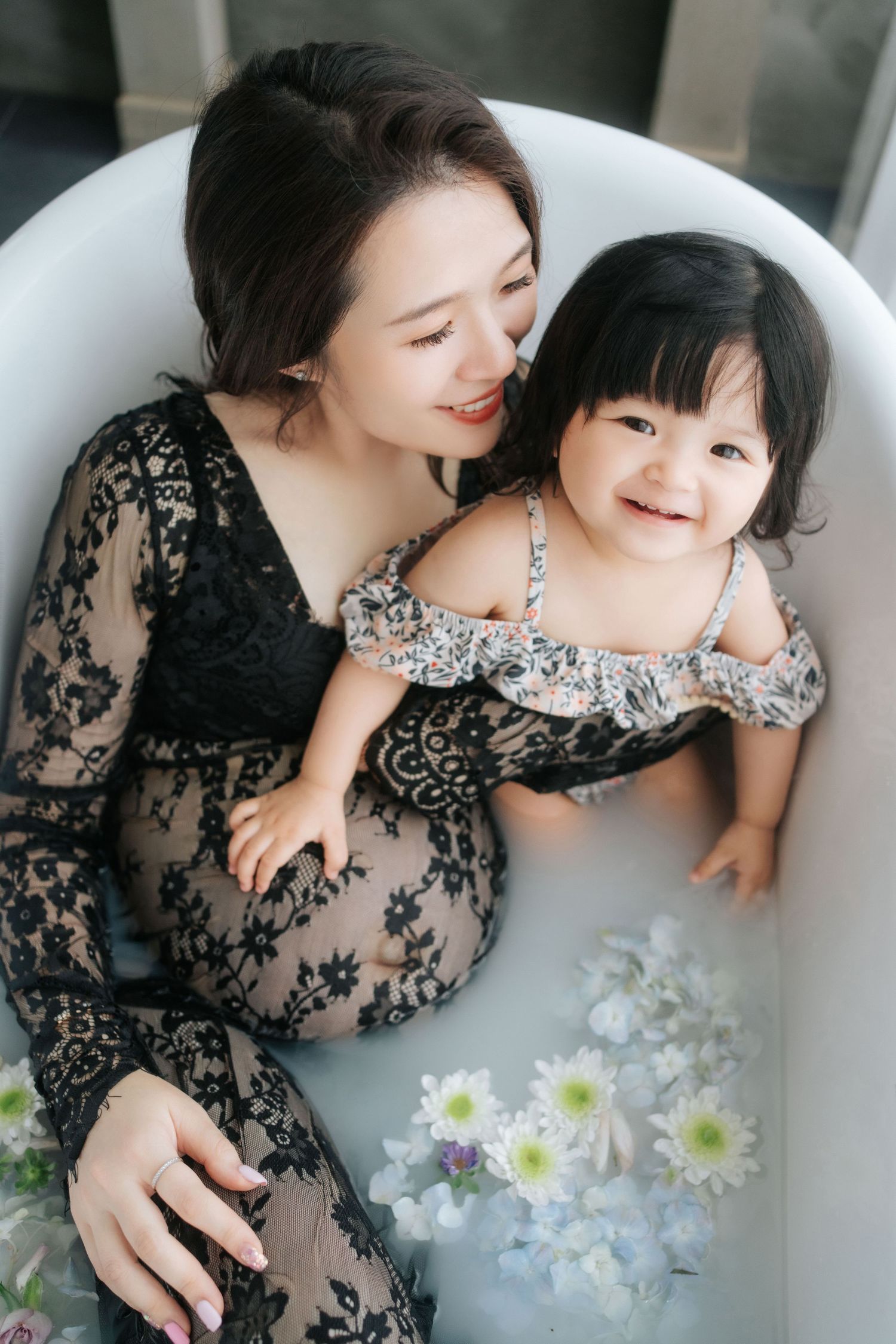 Elegant black lace dresses complement a serene bathtub scene with white flowers creating a dreamy atmosphere.優雅的黑色蕾絲洋裝與寧靜的浴缸場景和白色鮮花相得益彰