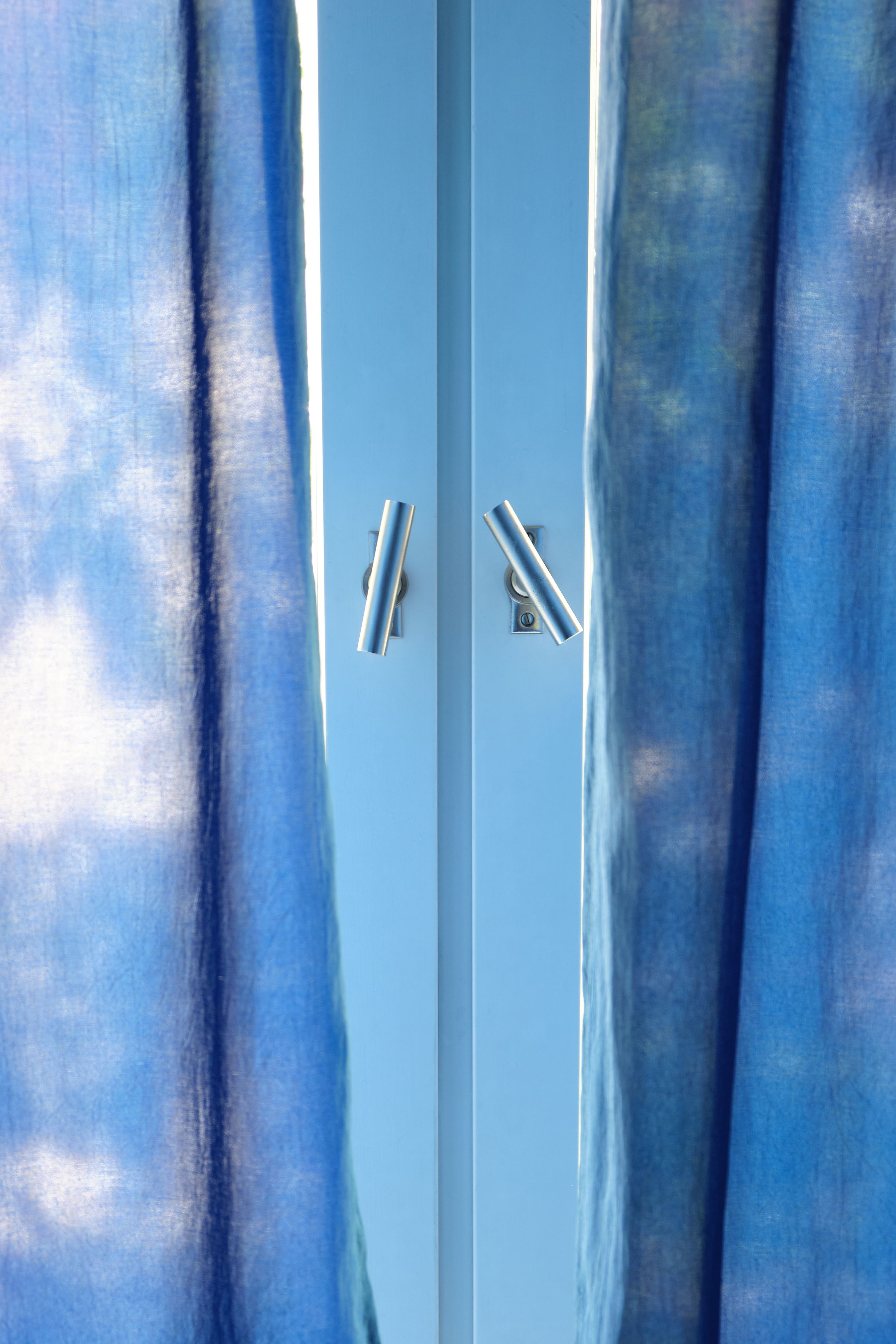 Abstract blue and white watercolor pattern with vertical stripes creating a soft, ethereal background texture.