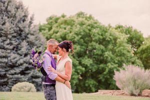 A couple shares an intimate moment together in a lush garden setting during a romantic outdoor photo session.