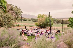 Panoramic view of an outdoor wedding ceremony setup in a rustic mountain landscape with chairs arranged in rows.