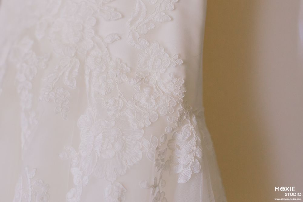Close-up detail shot of delicate lace pattern on a white wedding dress.