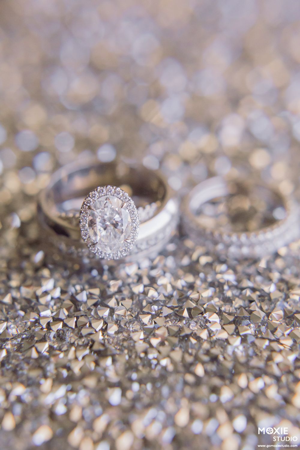 Close-up macro shots of a sparkling diamond engagement ring on glittery surface.