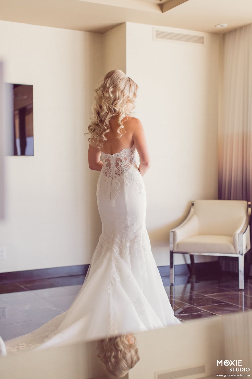 Back view of lace wedding dress with elegant train in bridal suite.