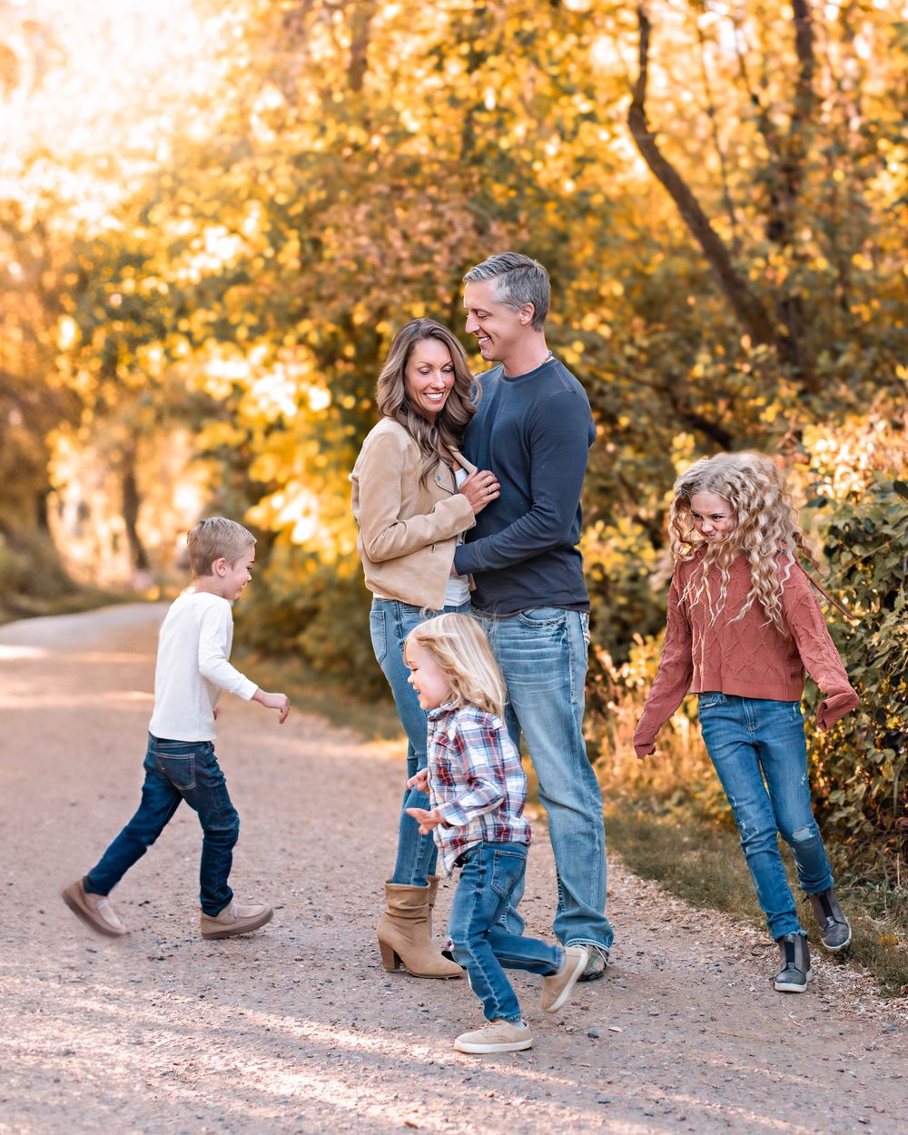 Mom and Dad embracing while children run around them
