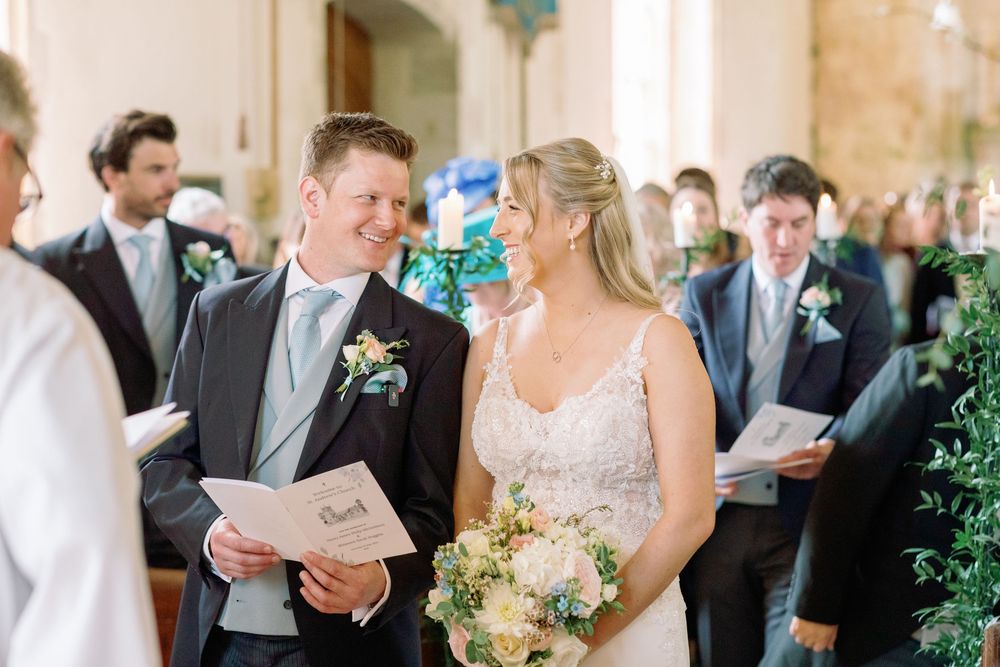 Wedding guests gathered in a sunlit stone hallway during an elegant celebration.
