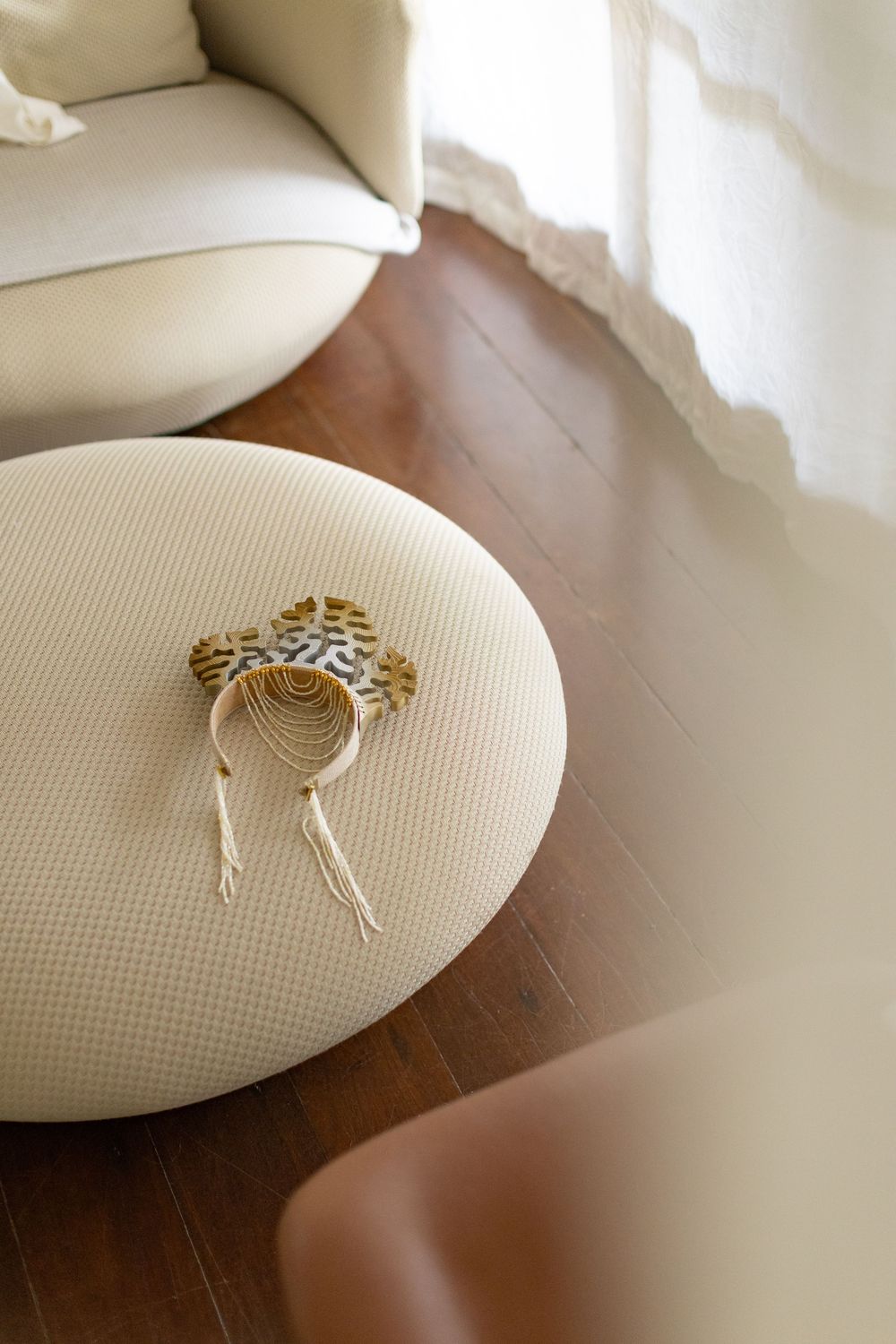 Wedding rings rest delicately on a white textured pillow against a dark wooden surface.