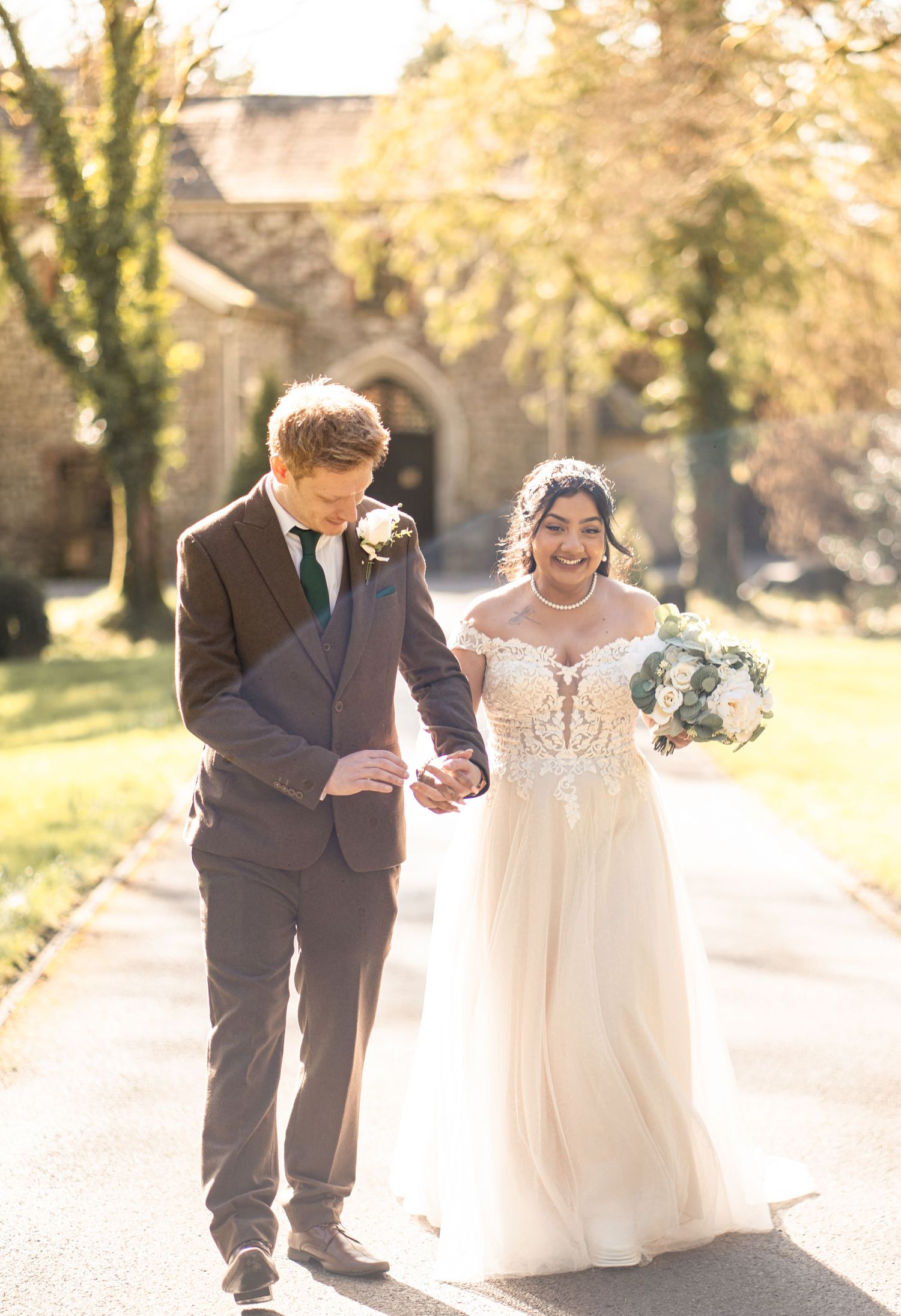 A couple shares joyful moments together in an autumn setting with golden sunlight and falling leaves.