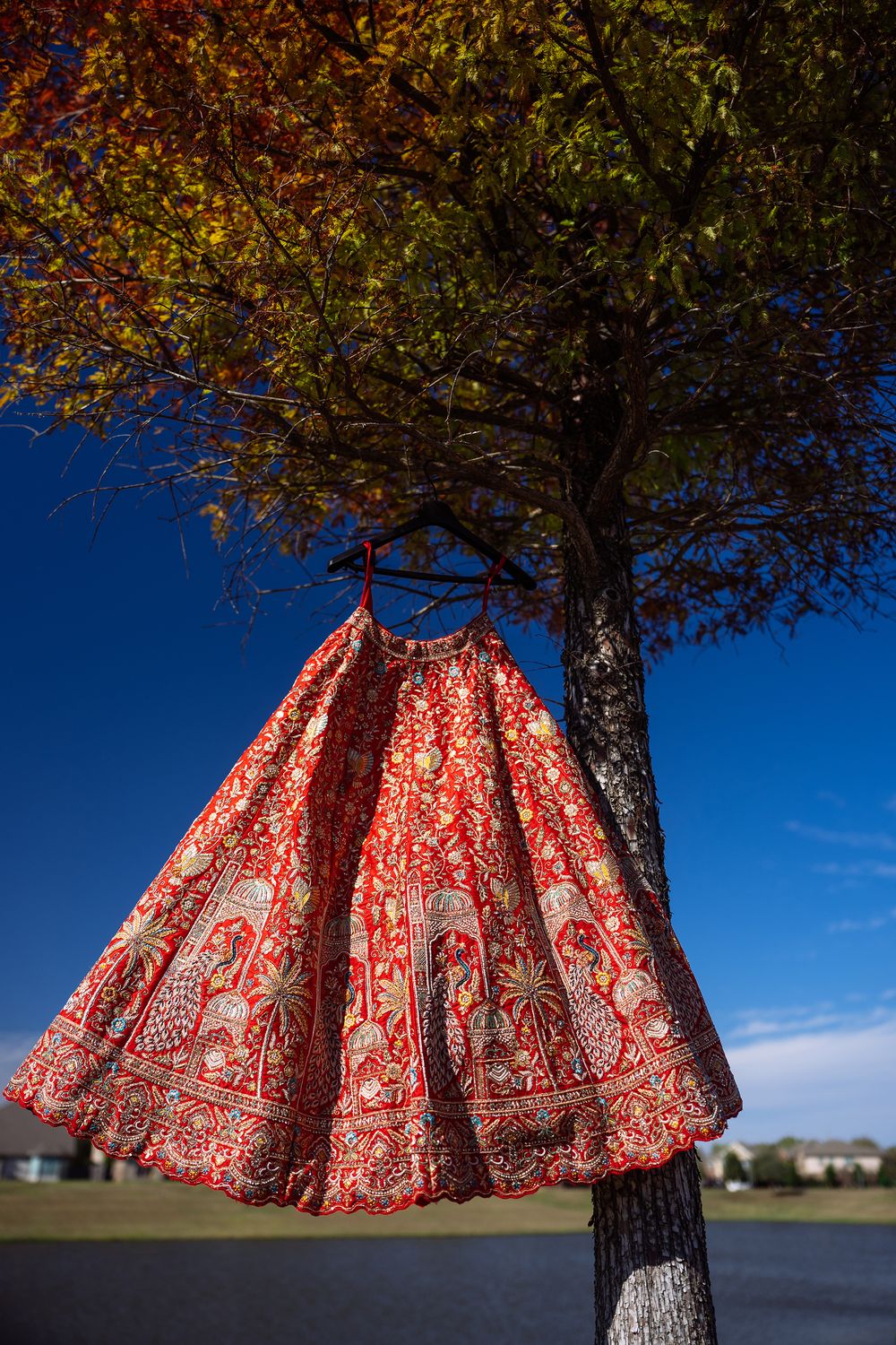 Red and white patterned skirt twirls against blue sky and autumn tree in artistic outdoor photo sequence.