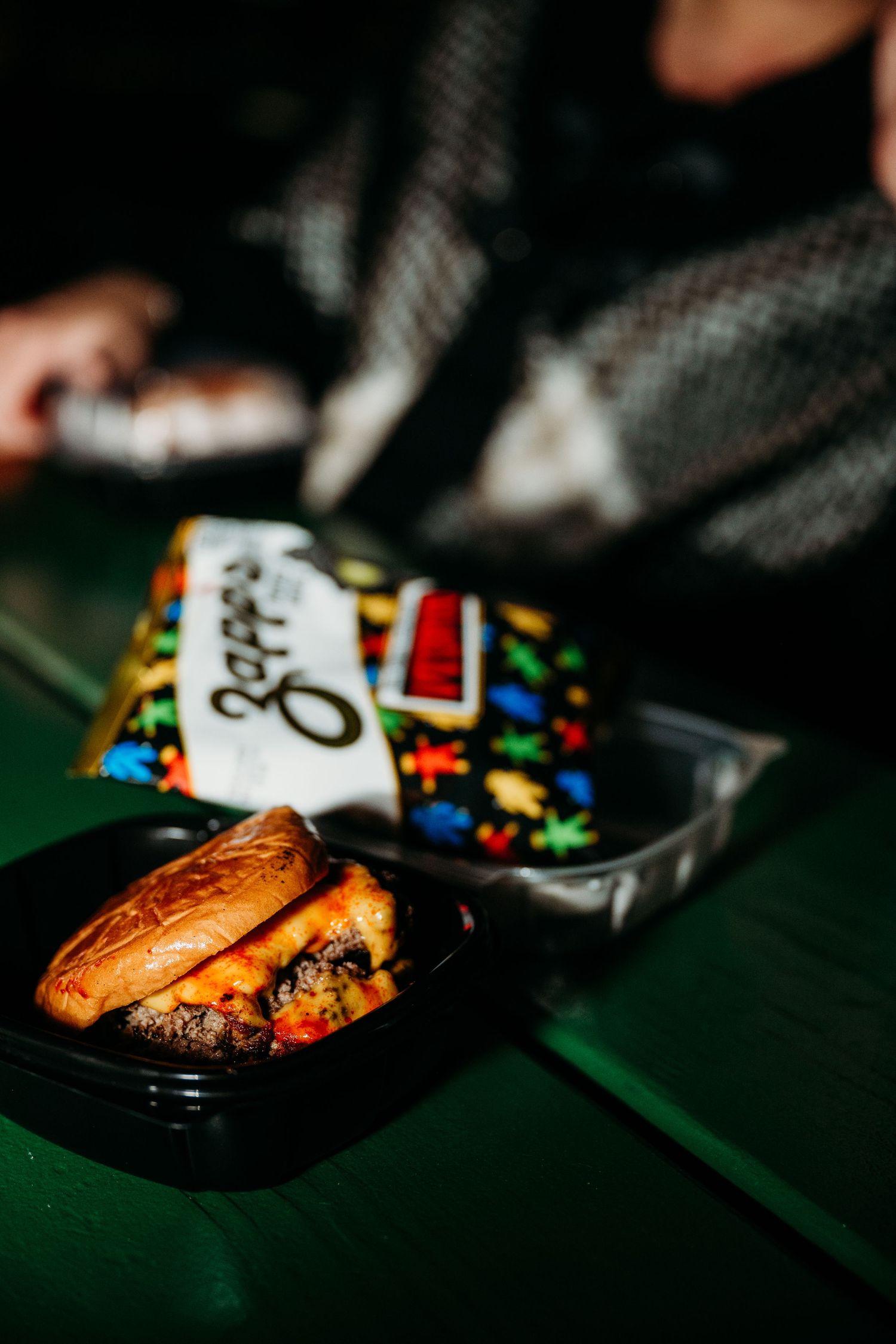 Close-up sequence of grilled chicken on black plates against a dark green background with colorful decorative elements.