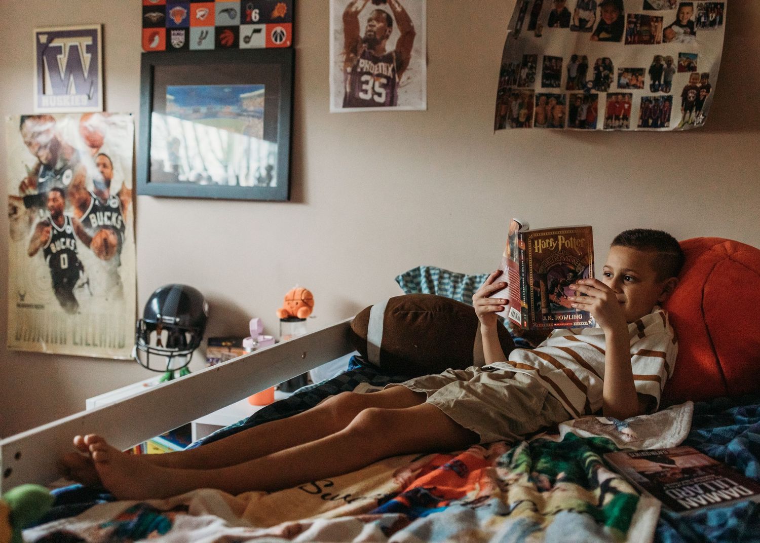A collection of sports memorabilia and photos displayed on a wall in a bedroom setting.