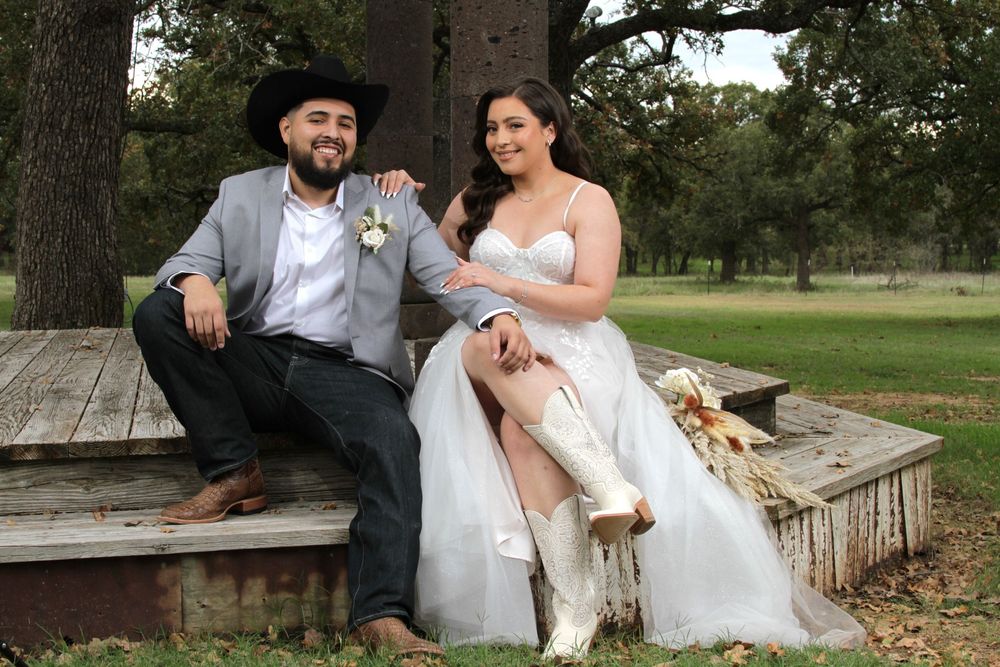 Wedding couple sharing tender moments on rustic outdoor bench.