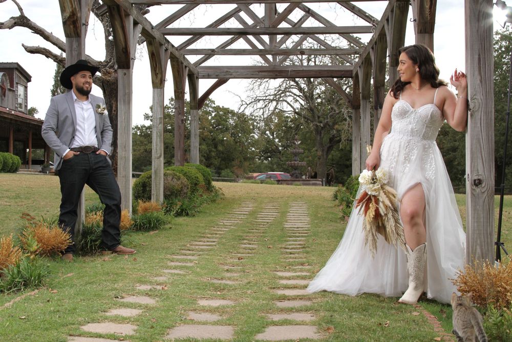 Wedding couple photographed along garden pathway with wooden pergola.