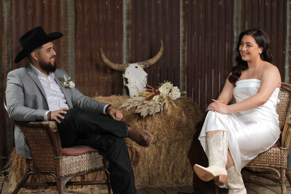 Rustic barn wedding portraits with couple posing on hay bales.