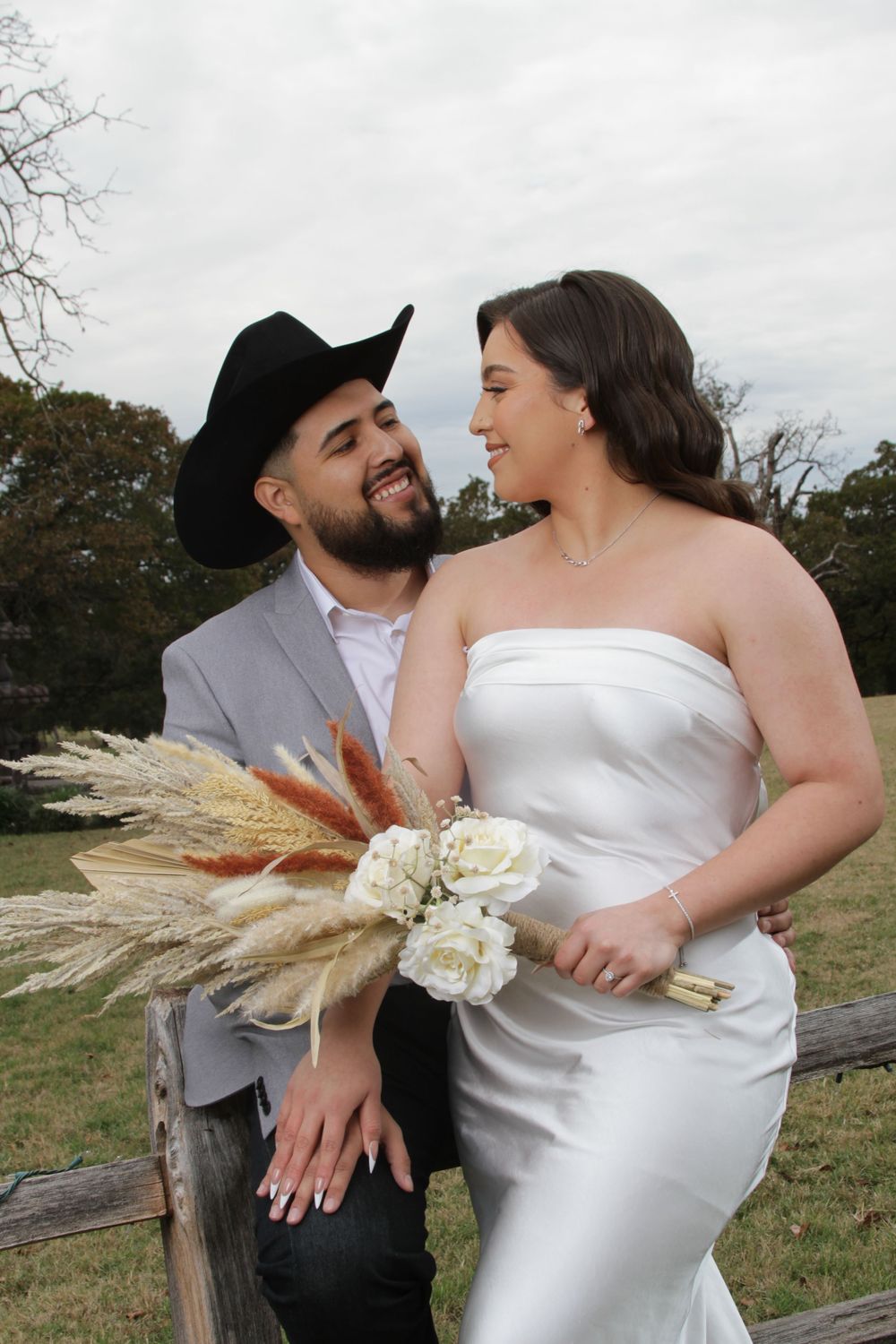 Candid wedding moments captured outdoors with pampas grass bouquet and natural scenery.