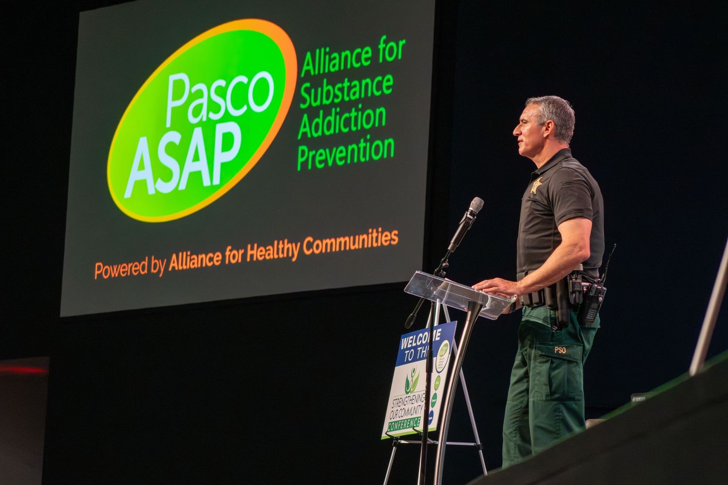 Conference presentation screen displaying green ASAP and Pasco logos on dark background.