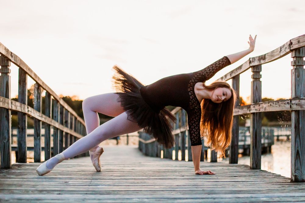 A series of artistic dance poses performed on a wooden pier or dock at sunset.
