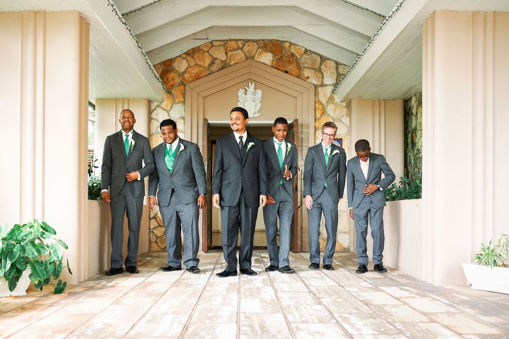 Group in formal attire standing together under an elegant covered entrance archway.