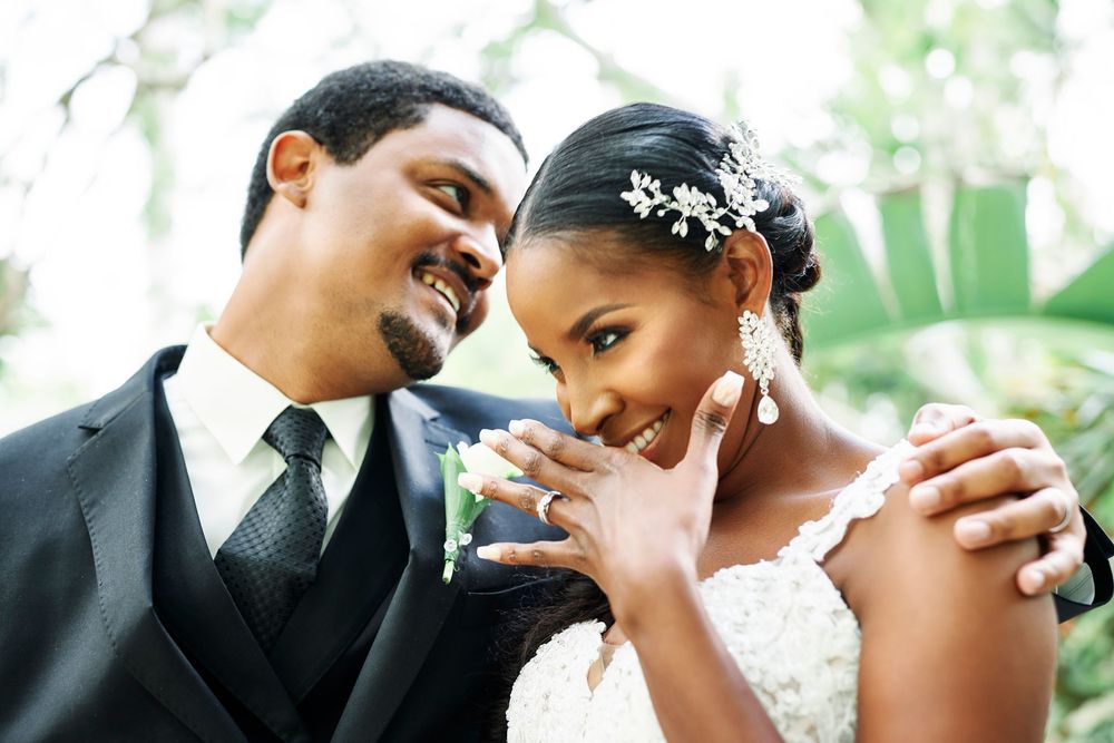 A joyful moment between a couple on their wedding day with delicate lace details and elegant formal attire.