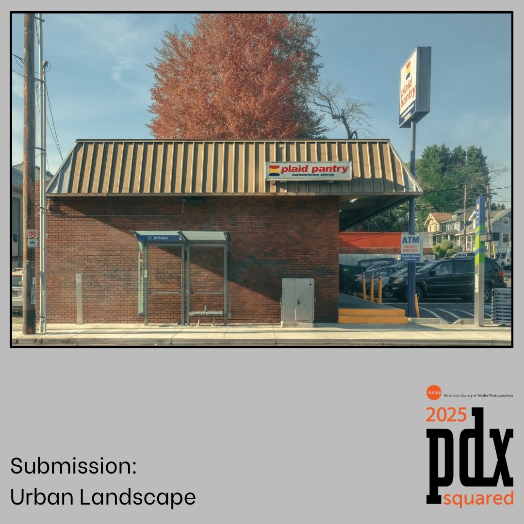 A small brick building with striped awning captured in autumn with a red-leaved tree behind it in Portland, Oregon.